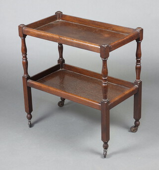 A 1930's rectangular oak 2 tier tea trolley on turned and block supports 76cm h x 71cm w x 40cm d 