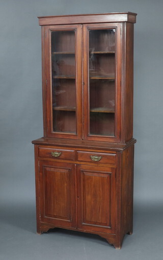 A Victorian mahogany bookcase on cabinet with moulded cornice, fitted shelves enclosed by glazed panelled doors, base with 2 drawers above double cupboard 211cm h x 90cm w x 43cm d 