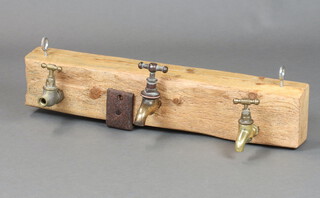 An amusing oak and brass coat rack, the coat hooks formed from taps, 11cm h x 66cm w (signs of old but treated worm) 
 