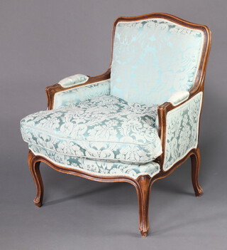 A French style show frame armchair upholstered in green material, raised on cabriole supports 88cm h x 78cm w x 63cm d (seat 36cm x 44cm) 
