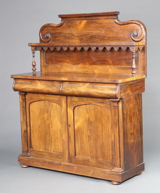 A Victorian rosewood chiffonier the raised back fitted a shelf, the base 2 secret drawers above cupboards enclosed by arched panelled doors, on bun feet 145cm h x 102cm w x 45cm d 