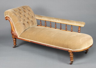 A Victorian carved walnut show frame chaise longue upholstered in mushroom coloured buttoned material, on turned supports 72cm h x 155cm w x 59cm d (seat 118cm w x 39cm d)  