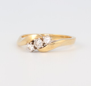 An 18ct yellow gold 3 stone diamond crossover ring, size N, approx. 0.17ct, 4.1 grams