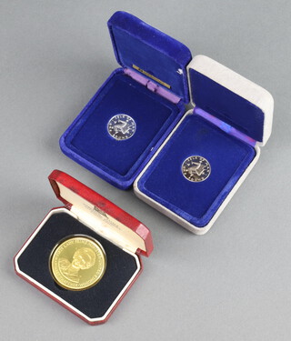 Two silver Isle of Man one pound coins together with a plated commemorative crown Margaret Thatcher dated 1979 