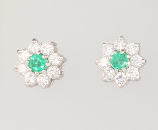 A pair of 18ct white gold emerald and diamond cluster earrings, the centre emeralds each approx. 0.25ct, the 16 brilliant cut diamonds each approx. 0.05ct, gross weight 4.5 grams, 10mm 