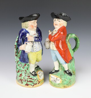 A 19th Century Staffordshire Toby jug in the form of a standing man wearing a blue coat "Hearty Good Fellow", ditto man with a red coat "Hearty Good Fellow", both 26cm 