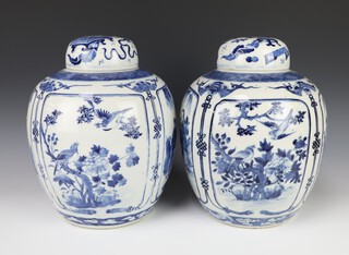 A pair of Chinese blue and white jars and covers decorated with panels of figures in gardens, panels of birds amongst trees, bearing a 4 character mark to the base 30cm 