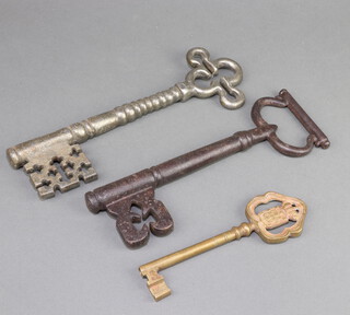 Two large church style door keys 25cm and a Continental gilt metal key decorated a coat of arms 17cm 