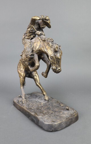 After Frederic Remington, a gilt bronze figure of a cowboy on rearing horse, on an oval base 37cm h x 26cm w x 14cm d