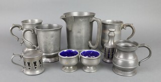 An Edwardian pewter quart spouted measure, the base marked Bell Inn Fetcham, a Victorian pewter pint tankard (dented in places), an Edwardian pewter pint tankard, 1 other, a half pint measure and a pewter 4 piece condiment set 