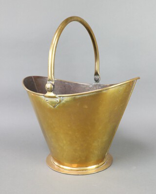 A brass helmet shaped coal scuttle with swing handle 26cm h