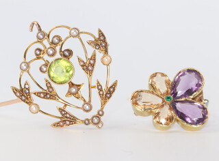 An Edwardian yellow metal amethyst, emerald and topaz pansy brooch, a peridot and seed pearl ditto set in a 15ct gold mount, gross weight 8.4 grams 