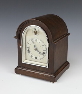 An Edwardian striking bracket clock with 10cm arched silvered dial, Roman numerals, striking on 5 gongs, the back plate marked Germany, contained in an oak case 21cm h x 16cm w x 14cm d, complete with key 