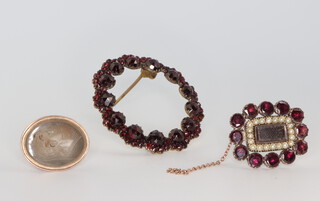 A Victorian yellow metal circular garnet set brooch, an in memoriam ditto set with seed pearls together with a yellow metal seal 