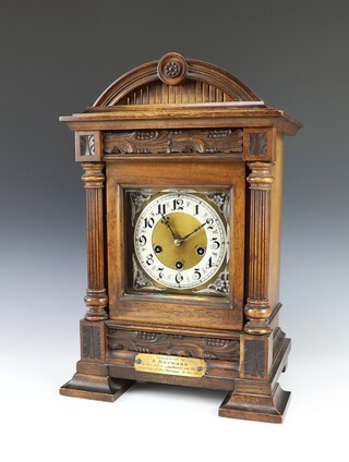 A German striking on gongs bracket clock with 15cm gilt dial, silvered chapter ring and Arabic numerals, contained in a carved oak case  47cm h x 30cm w x 21cm d, complete with pendulum and key  