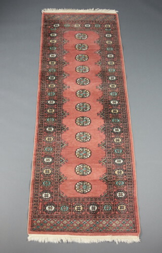 A pink and white ground Bokhara runner with 12 octagons to the centre within a multi row border 224cm x 80cm 