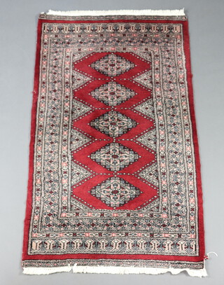 A red and white ground Bokhara rug with 5 diamonds to the centre 136cm x 80cm