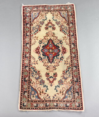 A white and floral patterned Persian rug with centre medallion 127cm x 60cm 
