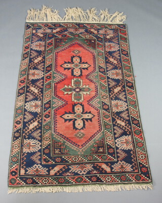 A pink, blue and green ground Afghan rug with 3 stylised medallions to the centre 191cm x 120cm 