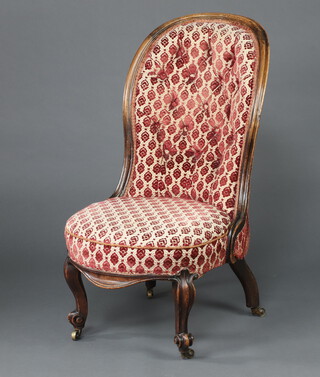 A Victorian mahogany show frame nursing chair upholstered in pink and white floral patterned material, on cabriole supports 