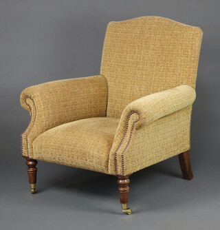 A Howard style armchair upholstered in light brown and patterned material, on turned supports, brass caps and casters 91cm h x 83cm w x 67cm d (seat 35cm x 42cm) 