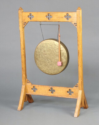 A Victorian dinner gong on a light oak Gothic style stand complete with beater 96cm h x 61cm w x 29cm d 