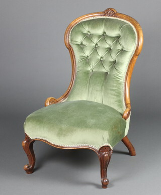 A Victorian bleached mahogany show frame nursing chair upholstered in green buttoned material raised on cabriole supports 86cm h x 53cm w x 52cm d 