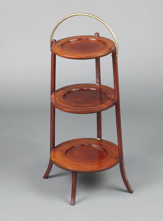 An Edwardian circular graduated 3 tier plant stand with gilt metal swing handle, raised on outswept supports  65cm h  