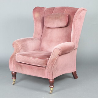 A Parkerknoll Victorian style winged armchair upholstered in pink material, raised on turned supports 95cm h x 78cm x 66cm 