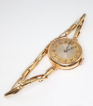 A lady's 9ct yellow gold wristwatch on a yellow metal 18ct strap, gross weight 16.5 grams 