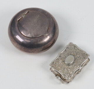 A Victorian rectangular silver vinaigrette with scroll decoration and floral grill Birmingham 1888, together with a circular silver portable ashtray, 27 grams 