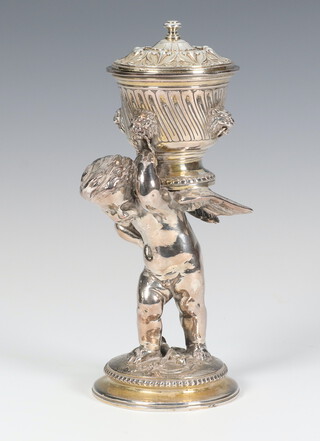 An impressive Elkington & Co silver plated cup and cover in the form of a cherub holding a cup above him, on a circular base 17cm 