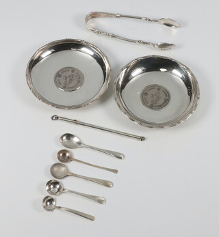 Two Sterling silver coin set dishes, pair of nips, swizzle stick and 5 mustard spoons, 146 grams 