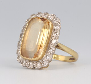 An 18ct yellow gold citrine and diamond cluster ring, the centre stone approx. 15mm x 10mm, the 20 brilliant cut diamonds each approx. .02 ct, size O, 6.9 grams