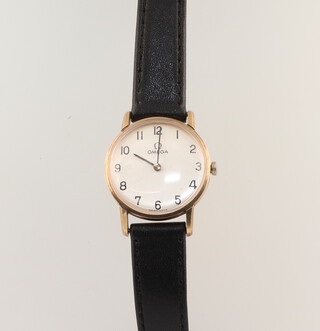 A lady's 9ct yellow gold Omega wristwatch on a leather strap, contained in a 32mm case 