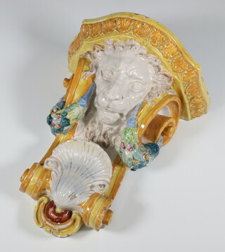 A Continental ceramic wall bracket with a lion mask shell and swags of flowers 32cm 