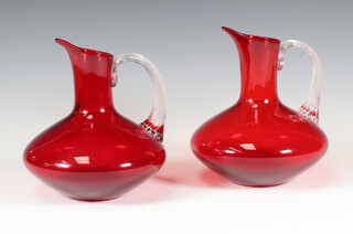 Two Whitefriars red ground jugs with clear handles 18cm 