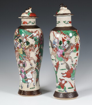 A pair of Chinese crackle glazed oviform vases and covers decorated with warriors 32cm 