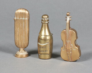 A brass vesta case in the form of a bottle of Veuve Clicquot Champagne 6cm, ditto of a violin 6cm and a gilt metal vesta case the base with seal 6cm  