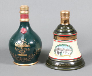 A 700ml pottery flagon of Glenfiddich 18 year old Ancient Reserve malt whisky 43% volume, together with a 75cl Wade 1989 Christmas decanter of Bells Scotch Whisky  