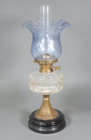 A Victorian clear moulded glass oil lamp reservoir raised on a gilt metal base with green glass shade and clear glass chimney, burners marked Duplex England 59cm  