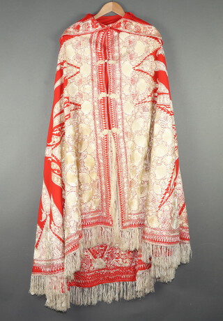 A hooded red robe with white floral embroidery and deep tassels 
