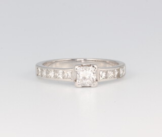 A white metal diamond ring with a princess cut centre stone approx. 0.25ct with diamond set shoulders, size J 1/2, 2.4 grams 