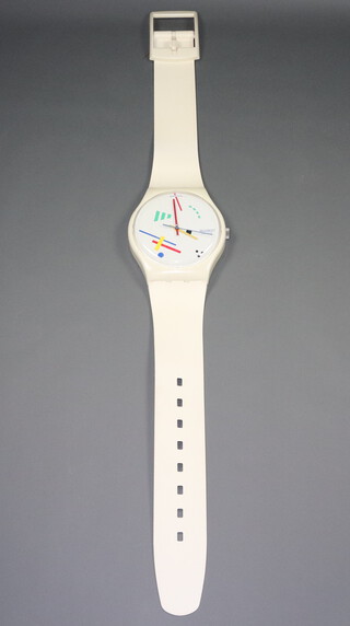 A 1987 Swatch battery operated wall clock in the form of an oversized Swatch wristwatch, having a 27cm dial 201cm h x 33cm w 