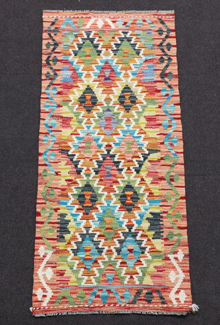 An orange, yellow and brown ground Chobi Kilim runner with overall geometric design 142cm x 62cm 