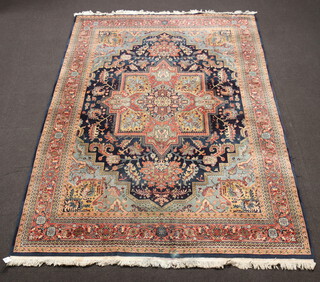 A blue and floral patterned machine made Persian style rug with central medallion 340cm x 253cm 