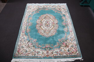 A green and floral patterned Chinese carpet with central medallion 374cm x 277cm 