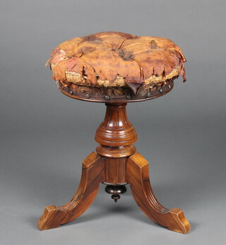 A Victorian walnut revolving adjustable piano stool, seat upholstered in buttoned leather, on a pillar and tripod base 