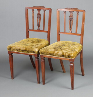 A pair of Edwardian, Georgian style stick and rail back bedroom chairs with over stuffed seats, raised on square tapered supports 87cm h x 44cm w x 42cm d 