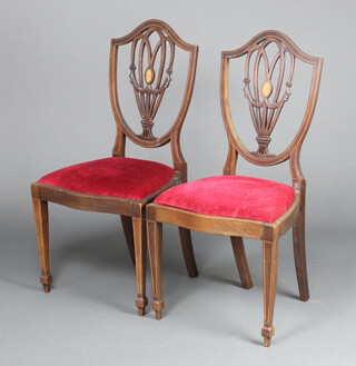 A pair of Edwardian inlaid mahogany Hepplewhite style shield back dining chairs, seats of serpentine outline raised on square tapered supports, spade feet 93cm h x 50cm w x 40cm d 